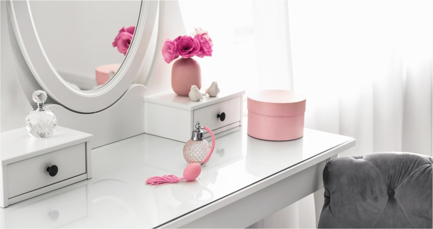 A white vanity with pink flowers and a mirror.