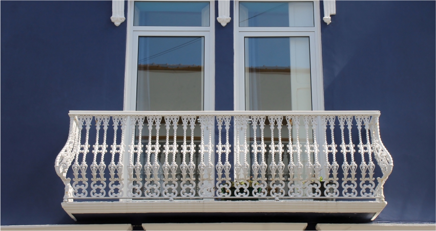 An ornate balcony on a blue building.