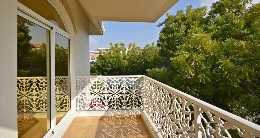 A balcony with wrought iron railings and glass doors.