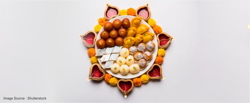 dry fruit and sweets in the thali with dia and flowers around it 