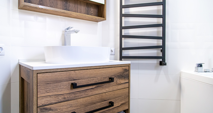 A bathroom with a wooden sink and towel rack.