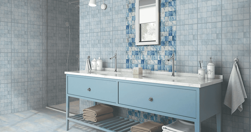 A bathroom with blue tiles and a white vanity.