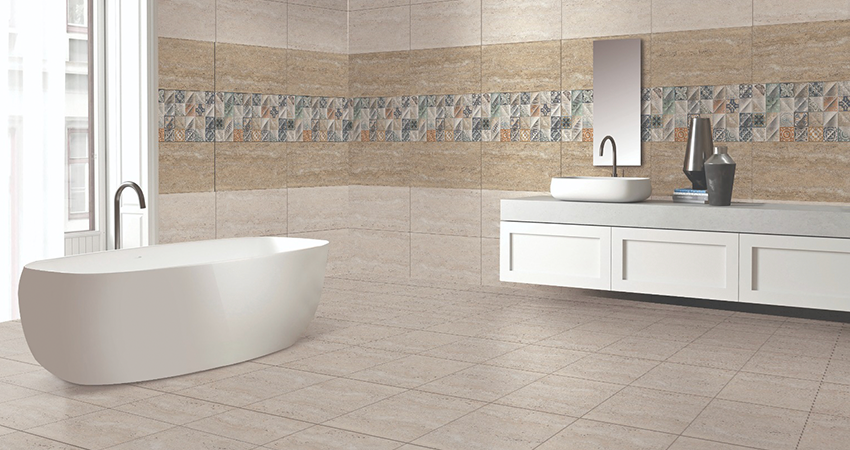 A bathroom with a white tub and tiled walls.