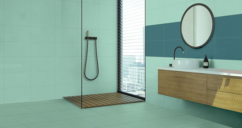 A bathroom with a blue and green tiled wall.