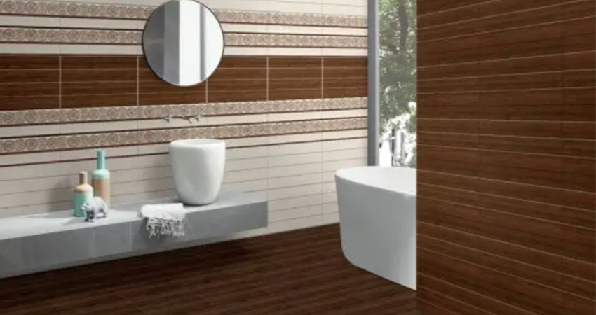 A bathroom with a wooden floor and brown tiled walls.