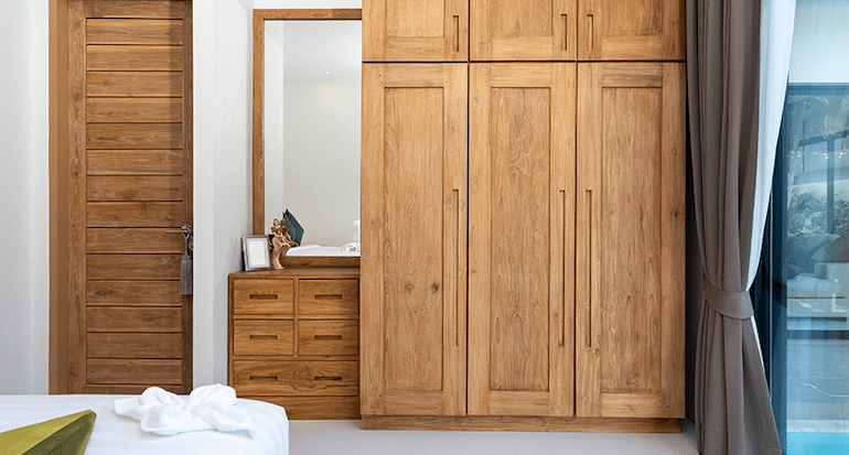 A bedroom with a wooden cupboard.