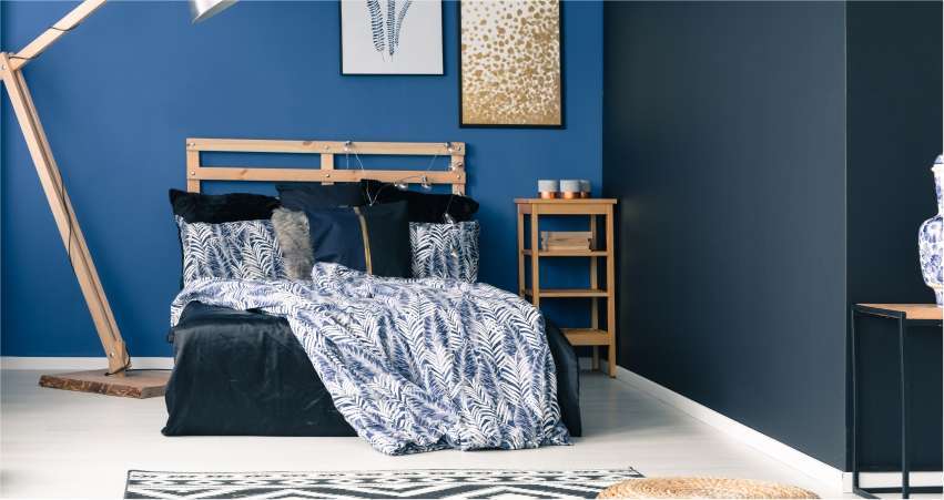 A bedroom with blue accent walls and wooden furniture.