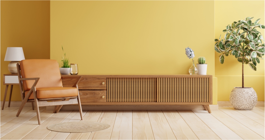 A small living room with a yellow wall and wooden furniture and floor.