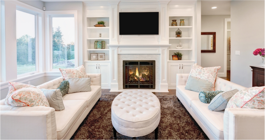 A living room with white furniture and a fireplace.