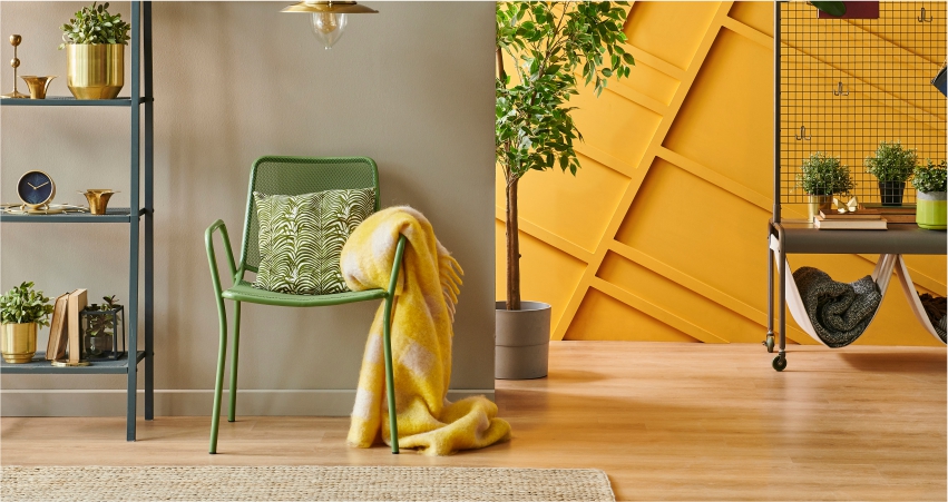 A living room with yellow walls and a green chair.