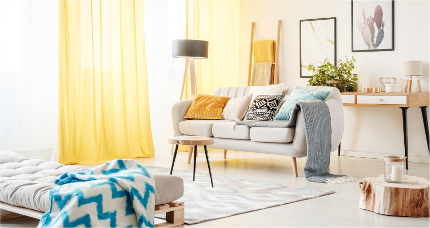 A living room with yellow curtains and a white couch.