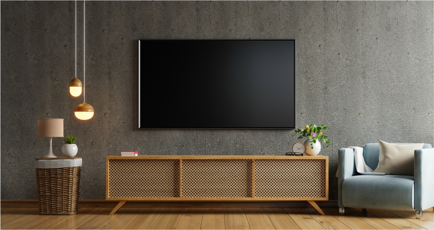 An empty living room with a black tv on the wall.
