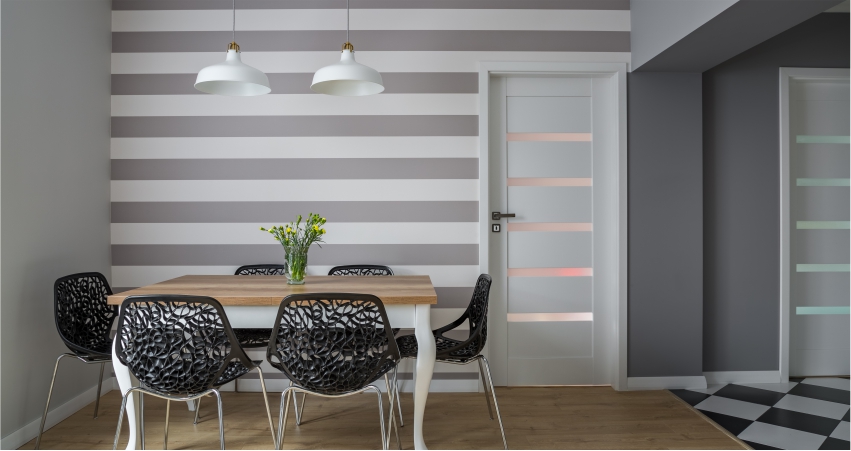 A dining room with striped walls and chairs.
