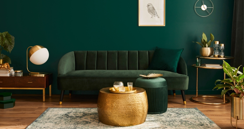A living room with green walls and gold accents.