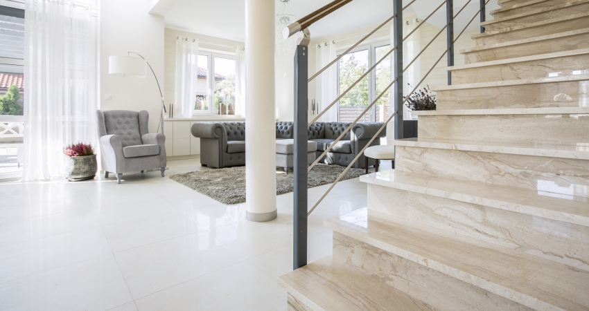 A white stone staircase in a living room.