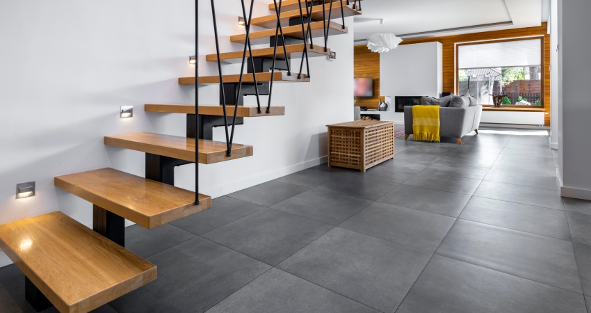 A wooden staircase leading to a living room in a modern home.