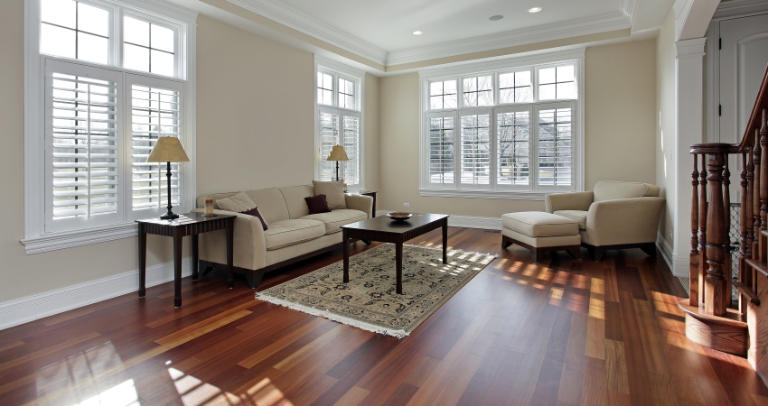 A living room with hardwood floors and windows.