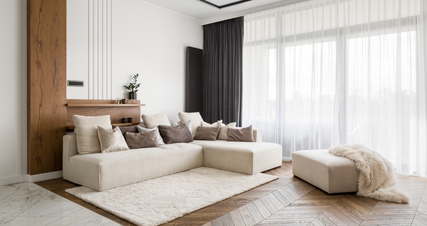 A modern living room with beige walls and white furniture.