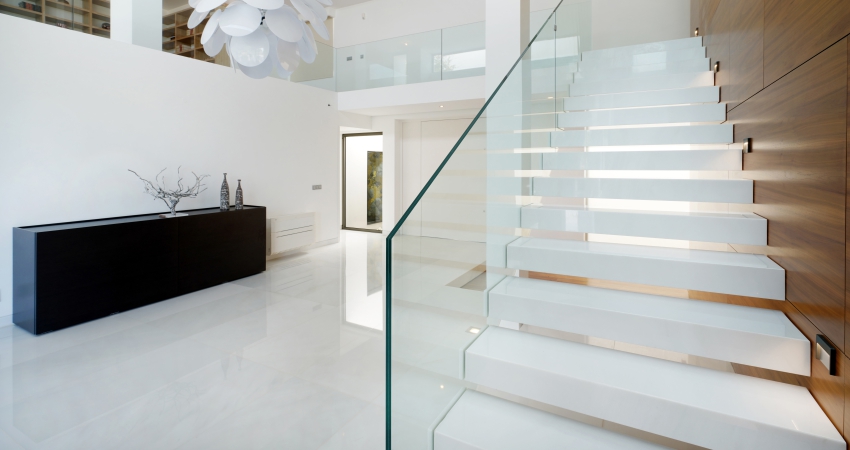 A white staircase with glass railings in a modern home.