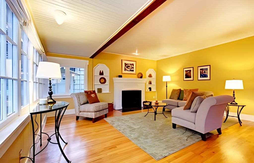 A living room with yellow walls and hardwood floors.