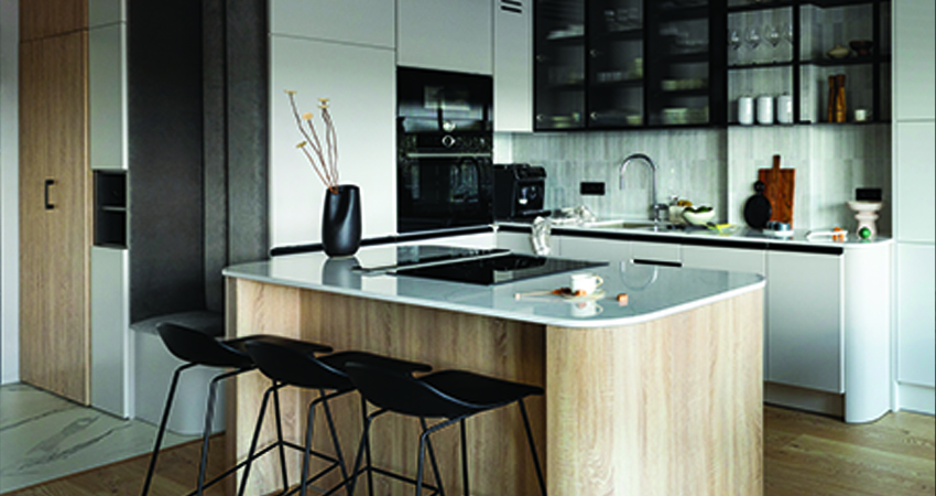 A modern kitchen with wooden cabinets and stools.