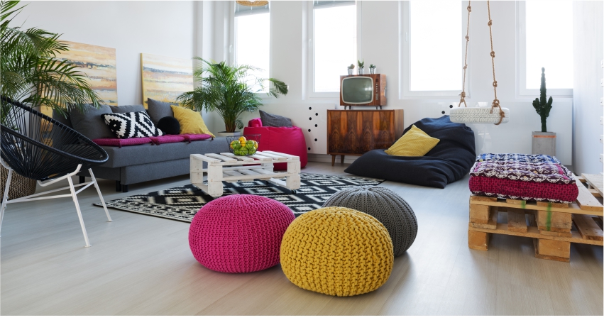 A living room with colorful pillows and bean bags.