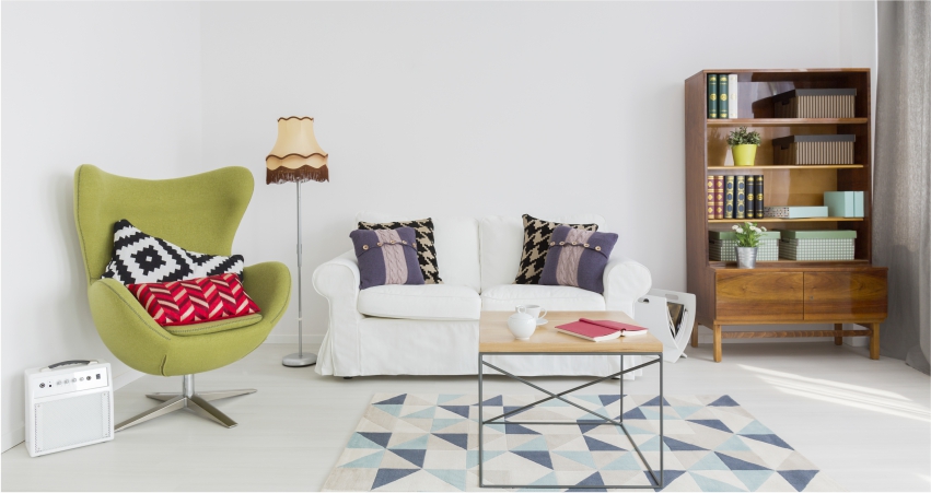 A living room with a green chair and bookshelf.