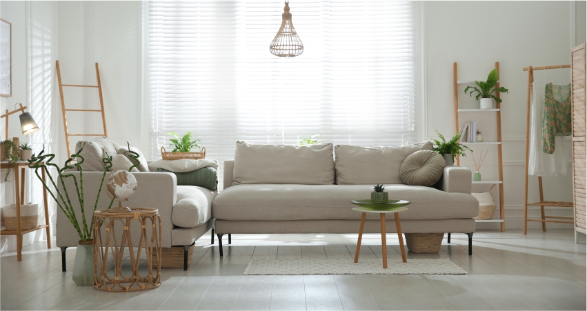 A living room with white furniture and plants.
