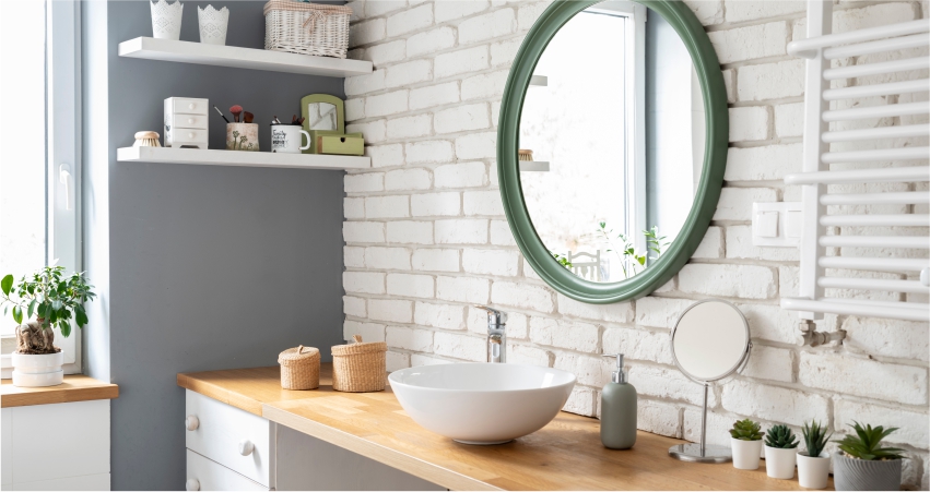 A white bathroom with a green sink and a round mirror.