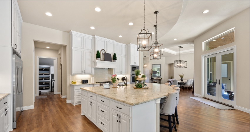 A large kitchen with white PoP ceiling, cabinets and a center island.