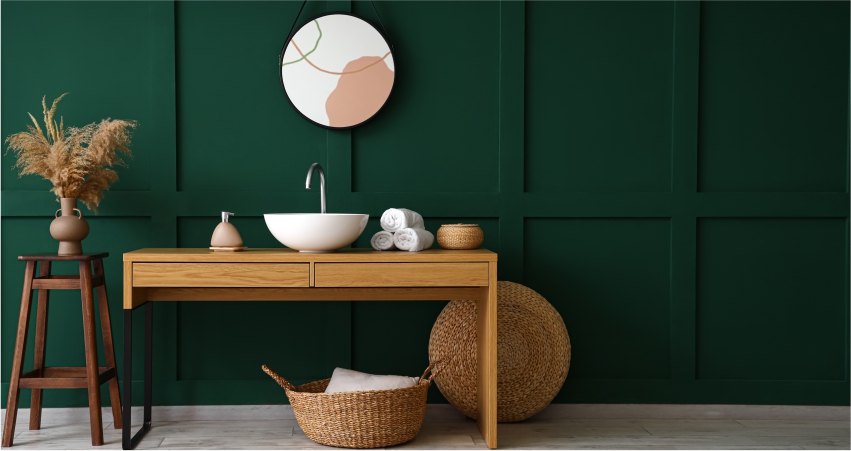A bathroom with green walls and a wooden vanity.
