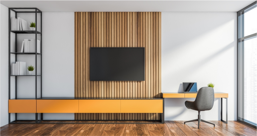 A modern living room with a beige wall, tv and a desk.