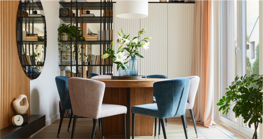 A dining room with blue chairs and a wooden table.