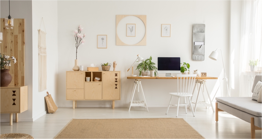 A white living room with a white couch, a white desk and wooden funiture.