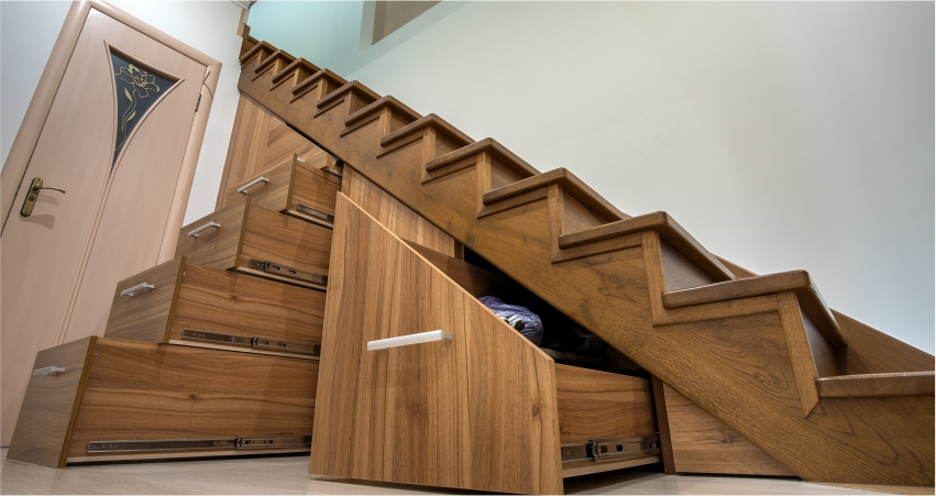A wooden staircase with a storage compartment under it.