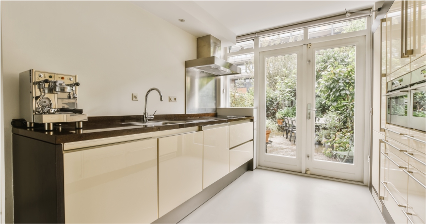 A kitchen with white cabinets and a door to the outside.