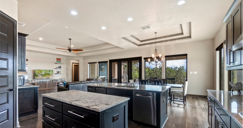 A kitchen with PoP ceiling, black cabinets and granite counter tops.
