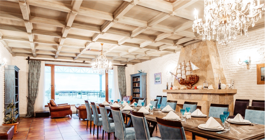 A dining room with blue chairs, wooden POP design and a chandelier.