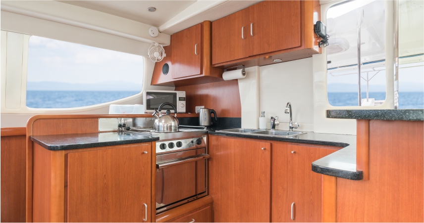 A kitchen on a boat with wooden cabinets.