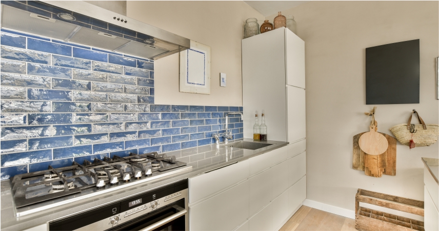 A blue tiled kitchen with a stove and oven.