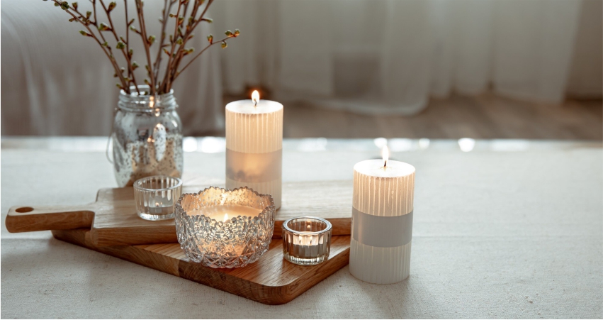 Three candles on a wooden cutting board.