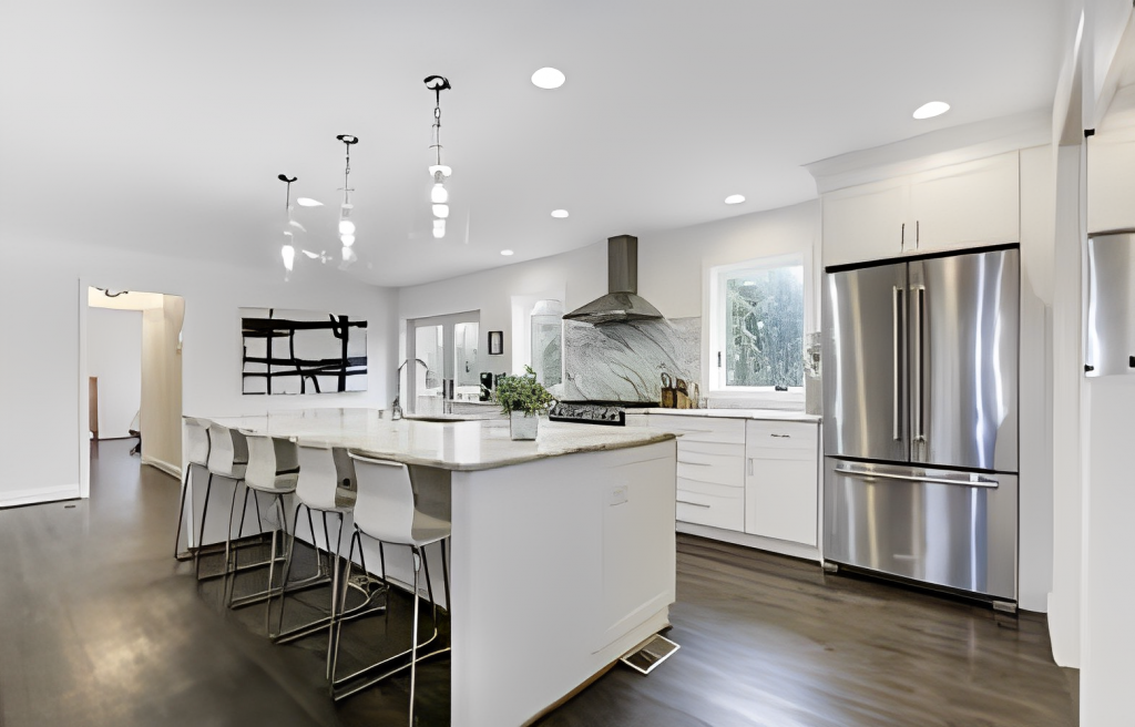 A white kitchen with stainless steel appliances and hardwood floors.
