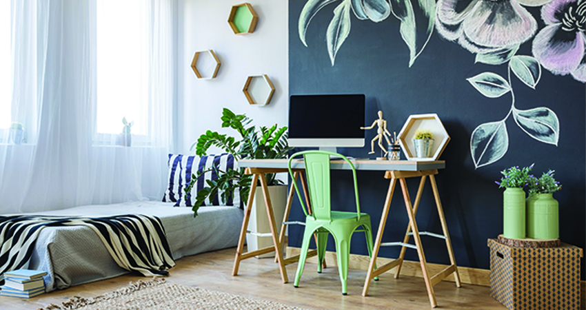 A room with a black wall, a wooden table and green chair.