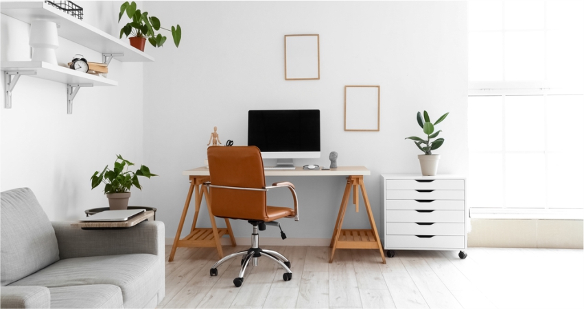 A home office with a desk, chair and plants.