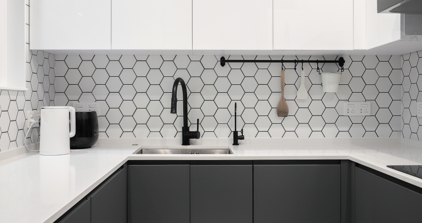 A kitchen with black and white hexagonal tiles.
