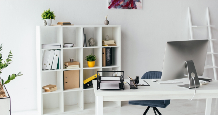 A white office with a desk and bookshelves.