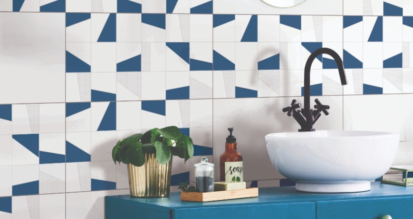 A bathroom with blue and white patterned wall tiles with white sink.