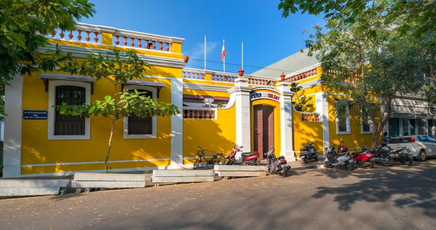 A yellow building with motorcycles parked in front of it.