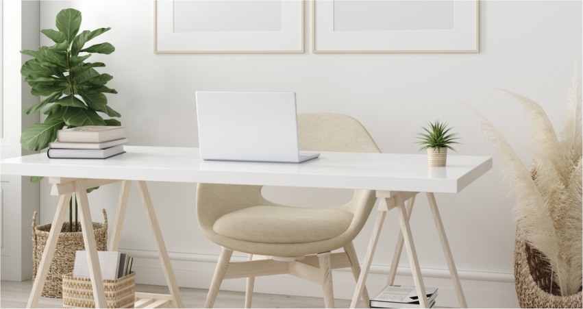 A white desk with a laptop and a plant in front of it.