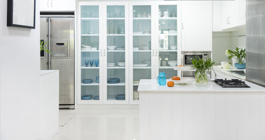 A white kitchen with glass cabinets.